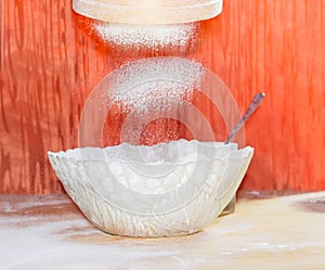 Flour during sifting into a glass bowl