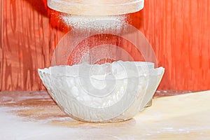 Flour during sifting into a glass bowl