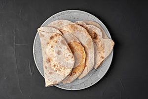 Flour tortillas with bran on a black background top view