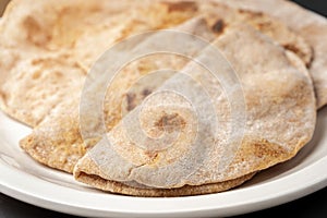 Flour tortillas with bran on a white plate close-up