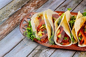 Flour tortillas stuffed with meat, beans and vegetables on wooden background