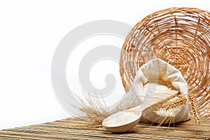 Flour and wheat grain with wooden spoon.