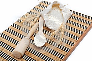 Flour and wheat grain with wooden spoon.