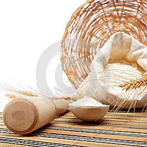 Flour and wheat grain with wooden spoon.