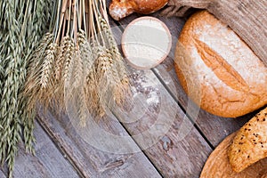 Flour in wooden bowl and bread assortment.