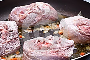 Floured osso buco in pan photo