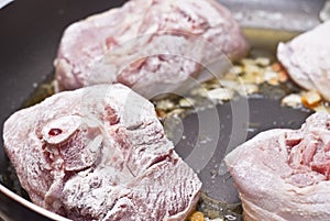 Floured osso buco in pan photo