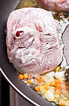 Floured osso buco in pan photo