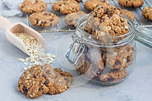 Flourless gluten free peanut butter, oatmeal and chocolate chips cookies in glass jar and on table, horizontal