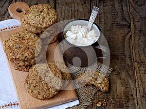 Flourless gluten free peanut butter, oatmeal, dried fruits cookies and cup of cocoa with marshmallows on wooden background. Horizo