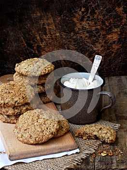 Flourless gluten free peanut butter, oatmeal, dried fruits cookies and cup of cocoa with marshmallows on wooden background. Vertic