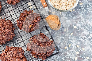 Flourless no bake peanut butter and oatmeal chocolate cookies on  cooling rack, horizontal, top view, copy space