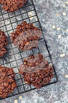 Flourless no bake peanut butter and oatmeal chocolate cookies on  cooling rack, vertical, top view