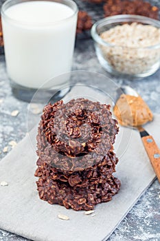 Flourless no bake peanut butter and oatmeal chocolate cookies with glass of milk, vertical