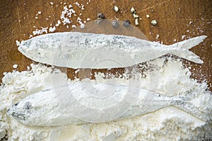 Floury fish on a wooden background