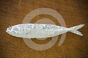 Floury fish on a wooden background