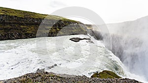 flow of Gullfoss waterfall and spray over canyon