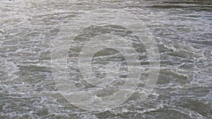 The flow of rapid mountain rivers. Chaotic movement of water bubbling after the waterfall.