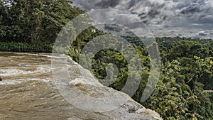 The flow of the stormy river collapses from the ledge. photo