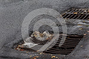 Flow of water during heavy rain and clogging of street sewage. The flow of water during a strong hurricane in storm sewers. Sewage photo