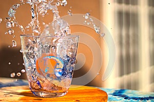 flow of water poured into a glass forming splashes