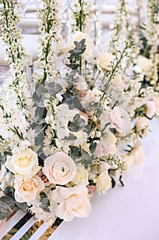 Flower arrangement bouquet of pink roses, ranunculus and white bells and eucalyptus on a white background