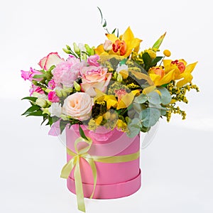 Flower arrangement in a hat box, a pot of pink for a girl on a gift with roses, orchids. Bouquet of beautiful flowers in