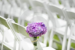 A flower arrangement next to chairs at a wedding