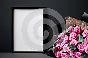 Flower arrangement. Pink flowers, black photo frame on pastel gray background. Copy space