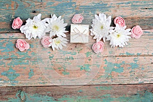 Flower border with gift box and copy space on old wooden turquoise background
