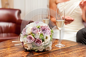 Flower bouquet and champagne glasses on wood table