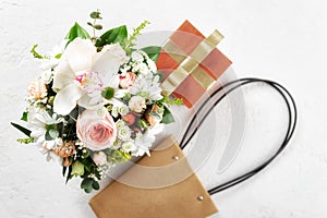 Flower bouquet with gift box and bag on white background Flat lay, top view floral Valentine Day Mother Day concept