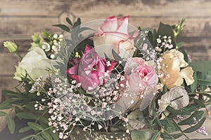 Flower bouquet with pink and white roses on wooden background