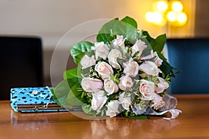 Flower bouquet and turquoise purse on wood table