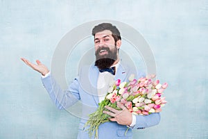 Flower bouquet for womens day. Bearded man with tulips. Flowers shop. Ideas to celebrate without breaking bank. Spring