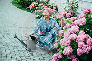 Flower care and watering. soils and fertilizers. happy woman gardener with flowers. woman care of flowers in garden