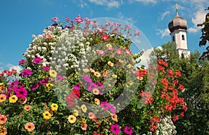Flower column with petunias and alyssum, against blue sky. tourist resort Gmund