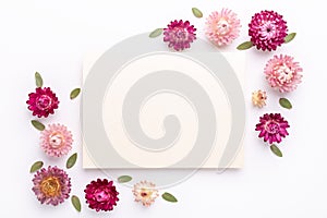 Flower composition. Blank of paper and frame made of dry flowers on white background. Flat lay. Top view. Copy space