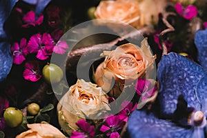 Flower composition with purple orchid flowers and soft orange roses