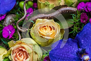 Flower composition with purple orchid flowers and soft orange roses