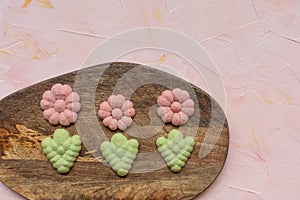 Flower cookies on a wooden board on a pink background . Spring holidays cooking concept