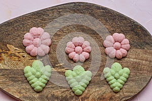 Flower cookies on a wooden board on a pink background . Spring holidays cooking concept
