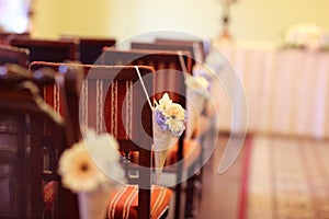 Flower decoration on chairs at wedding reception