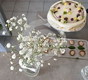 Flower decoration in focus with cake and party snacks on the background