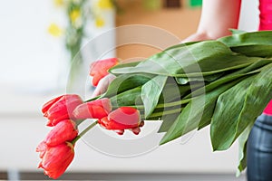 Flower delivery florist holding red tulip bouquet