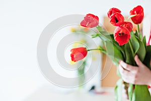 Flower delivery florist holding red tulip bouquet
