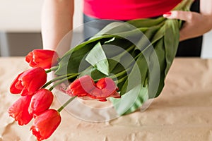 Flower delivery florist holding red tulip bouquet