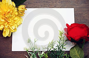 Flower frame with white Blank Paper on Wood Background. Flat Lay Top View