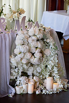 Flower garland of pine-shaped roses hangs from the table. Wedding decoration,floristry