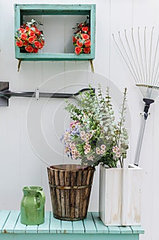 Flower on green bench with white wood panel wal